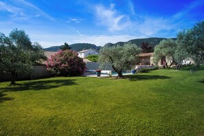 A well-maintained grassy area with trees and a pool, surrounded by hills. - Just a short walk from the Luberon Mountains—accommodations for up to six people (Maubec)