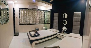 A bedroom with a bed, bedside tables, a mirror, and a window with curtains. - Nice Guest House (Mumbai)