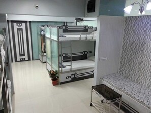 A bunk bed room with a small table and a potted plant. - Nice Guest House (Mumbai)