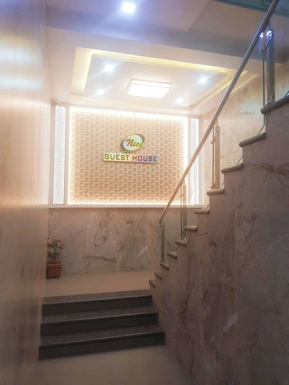 A staircase leading to a room with a sign reading 'Nice Guest House.'
