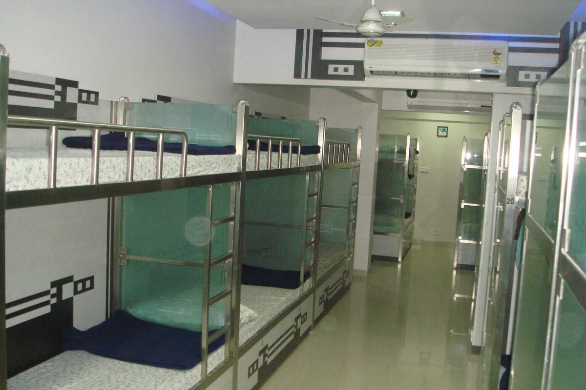 A corridor with bunk beds, a ceiling fan, and an air conditioning unit.