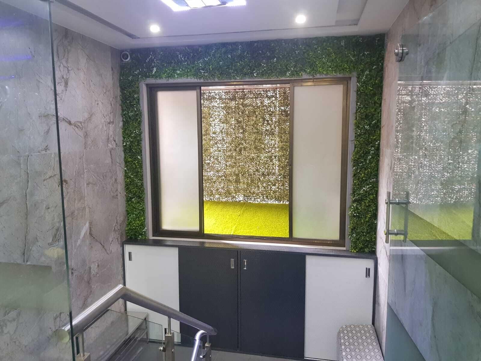 Une salle de bain moderne dotée d’une douche à parois de verre, d’un mur en marbre et d’un panneau mural décoratif vert.