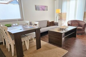 A modern living room with a dining table, chairs, a sofa, and a coffee table. - DO01 Holiday bungalow near the beach and city (DOMBURG)