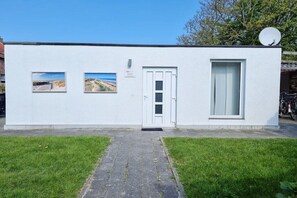 A white building with a door, two windows, and a satellite dish. - DO01 Holiday bungalow near the beach and city (DOMBURG)