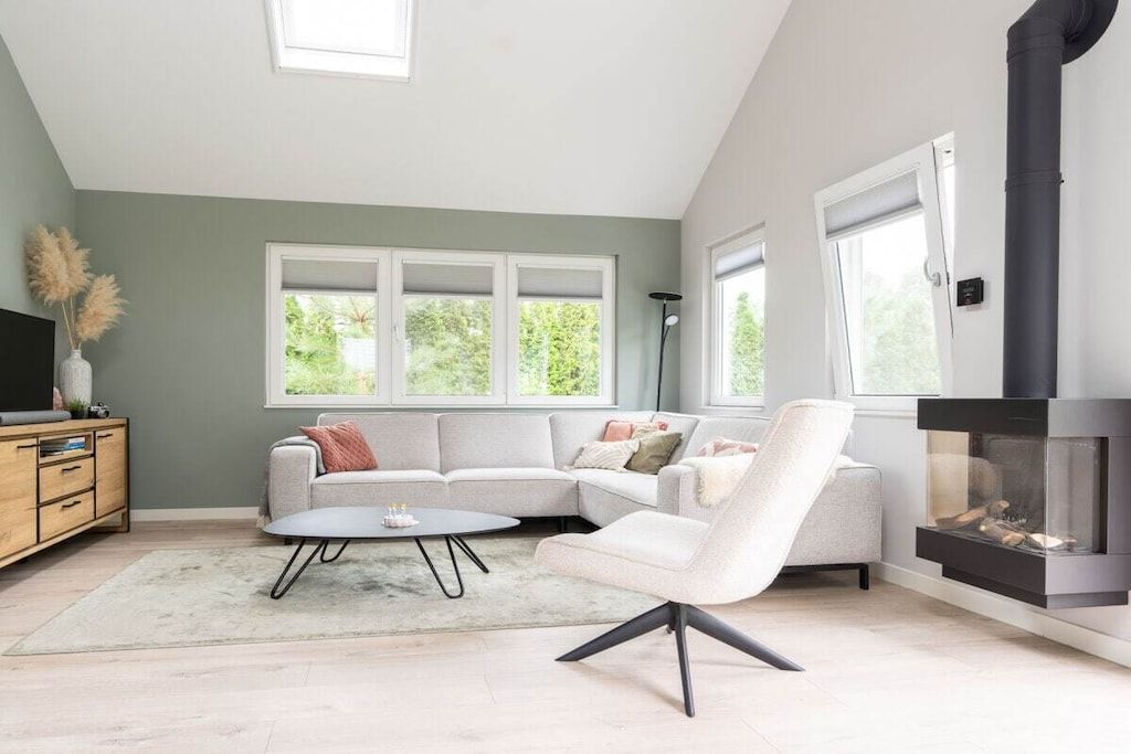 A modern living room with a sectional sofa, a round coffee table, and a fireplace.