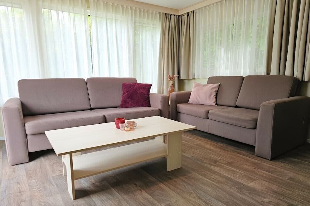 Una sala de estar con dos sofás, una mesa de centro y un florero.