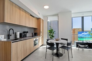 Una cocina moderna con armarios de madera, horno empotrado y cafetera.