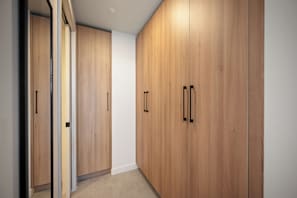 Un pasillo con armarios de madera y una pared blanca.
