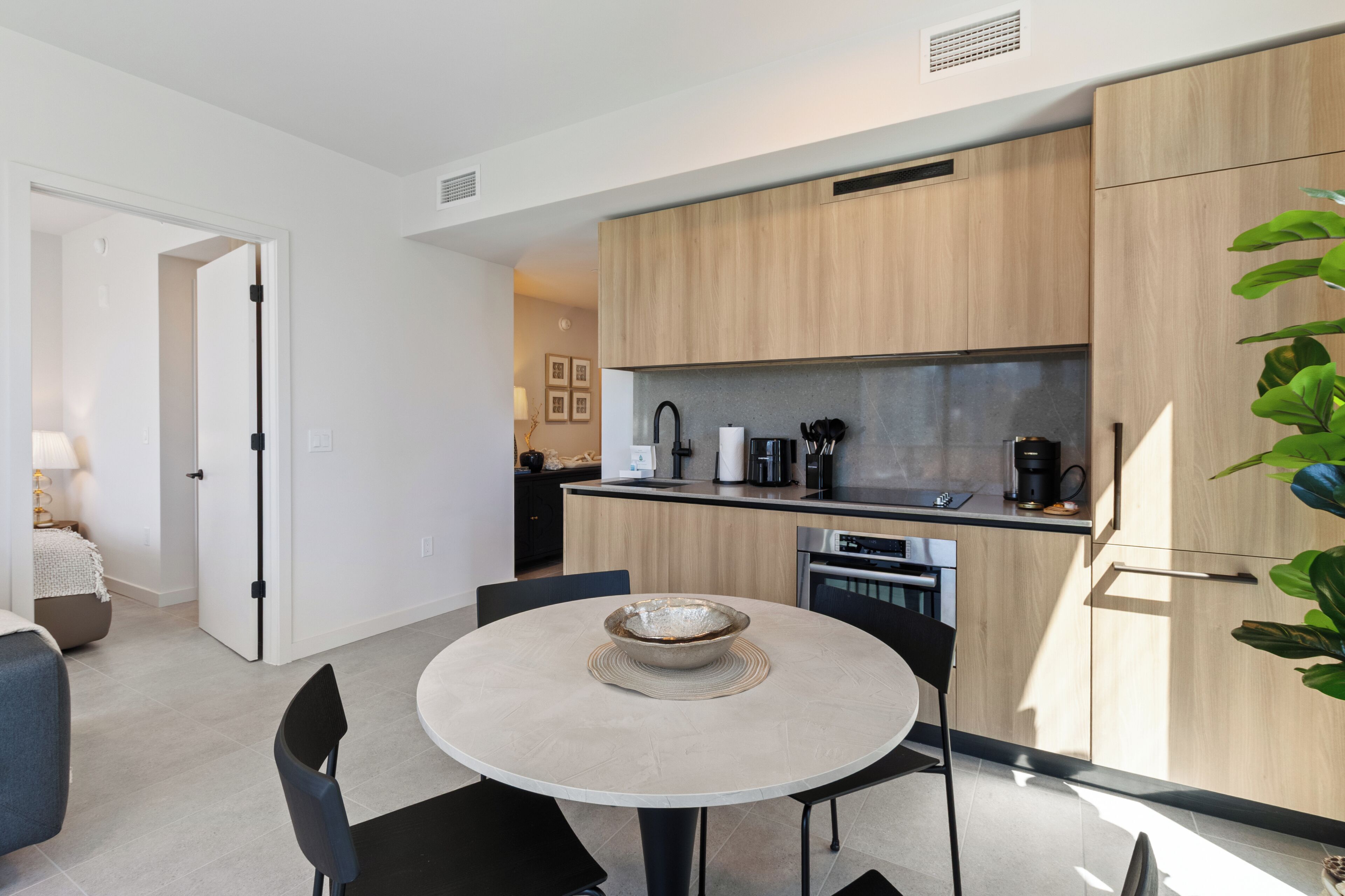 Una cocina moderna con armarios de madera, horno empotrado y cafetera.