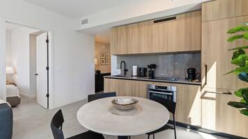 Una cocina moderna con armarios de madera, horno empotrado y cafetera.