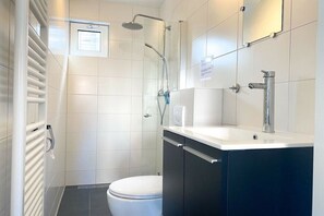Ein modernes Badezimmer mit Toilette, Dusche und Waschbecken.