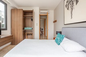 Ein Hotelzimmer mit Bett, Schreibtisch, Kleiderschrank und Klimaanlage.
