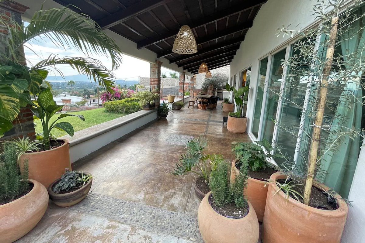 A covered outdoor area with potted plants, a patio table, and chairs.