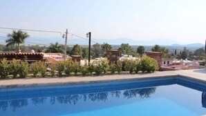 Une piscine offrant une vue dégagée sur le paysage environnant, notamment sur les bâtiments et la végétation.