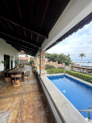 A covered outdoor area with a pool, seating, and potted plants. - Private Heated Pool - Lake View House - Golf Club (Chapala)