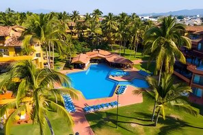 A resort with a central swimming pool surrounded by palm trees and lounge chairs. - Estudio a 10 Pasos de la Playa Vallarta (Puerto Vallarta)