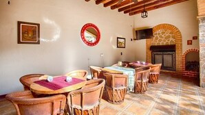 Un intérieur rustique avec des meubles en bois, une cheminée et un ventilateur de plafond.