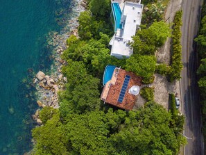 An aerial view of a property with a swimming pool, a separate pool area, and lush greenery. - Amazing View to los Arcos -4 Bedroom Villa (Puerto Vallarta)