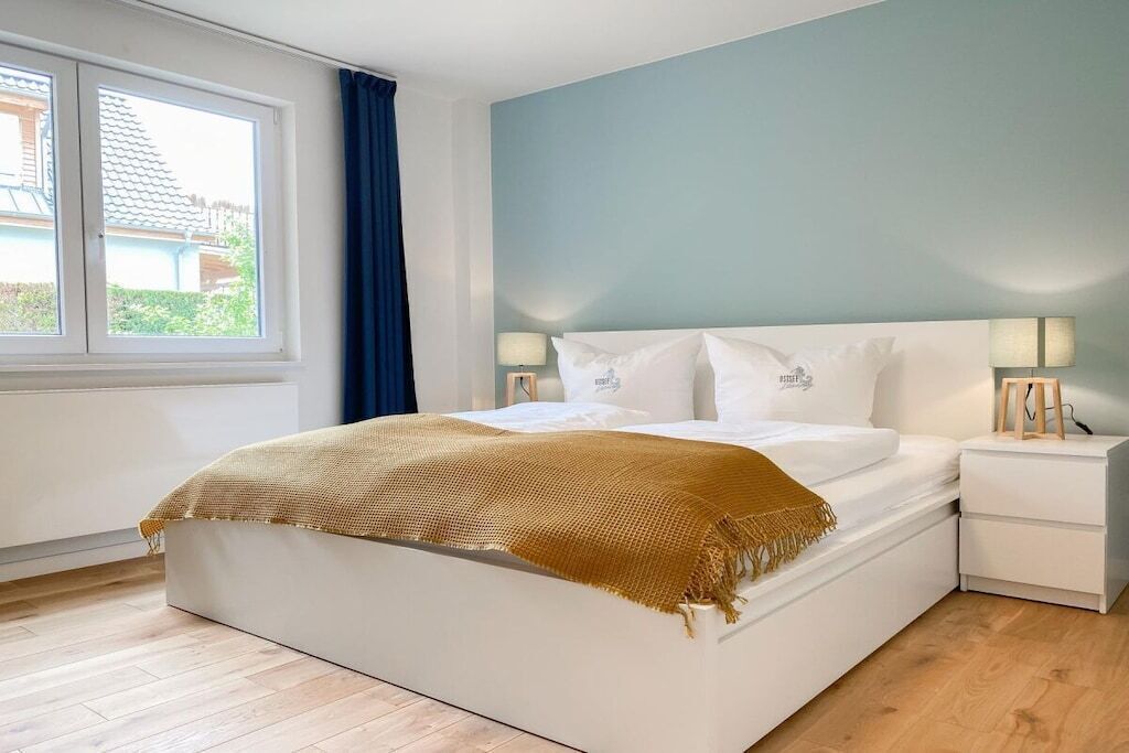 Une chambre à coucher avec un lit, des tables de chevet et une fenêtre.