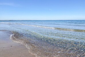 Une plage à l’eau claire, avec un rivage bien visible.