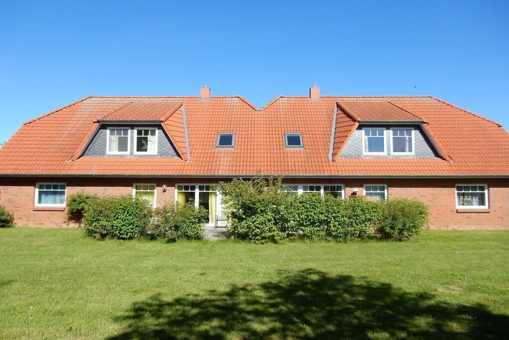 A two-story house with a sloped roof, a front entrance, and a well-maintained lawn.