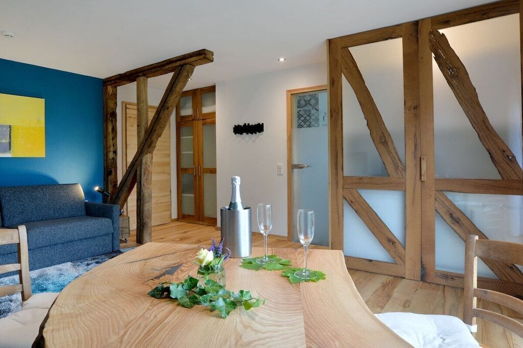 A room with a wooden table, a sofa, and a door with glass panels.