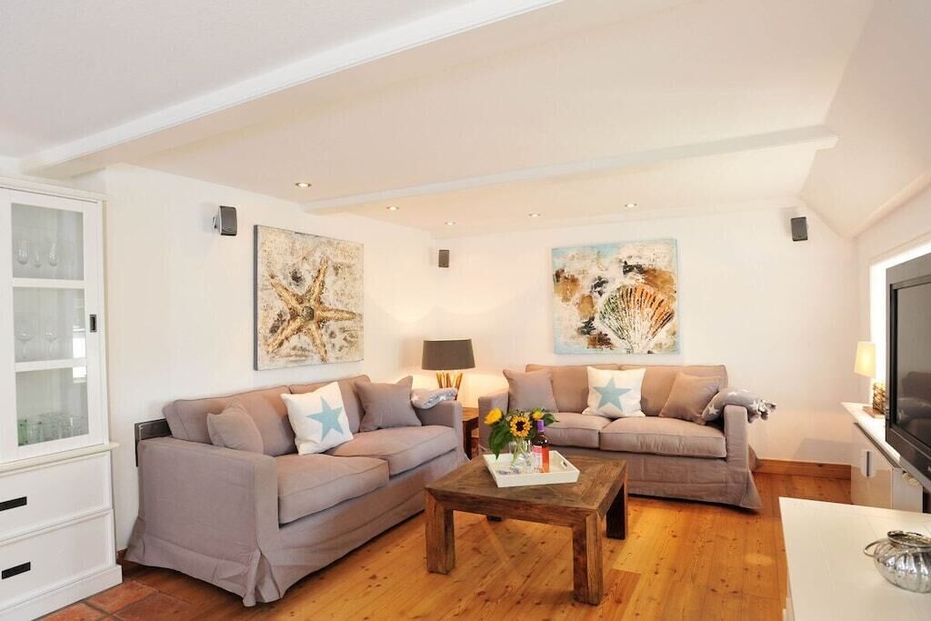 A living room with two sofas, a coffee table, and artwork on the walls.