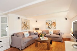 A living room with two sofas, a coffee table, and artwork on the walls. - Holiday apartment in Sylt with 2 bedrooms (Keitum)