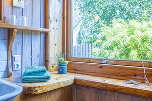 A wooden interior with a window, a towel, and a potted plant. - Natur&Strand Vacation Rental (Flensburg)