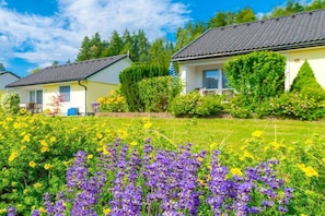 Ein Wohngebiet mit zwei Häusern, eines mit grauem Dach und das andere mit gelber Fassade.