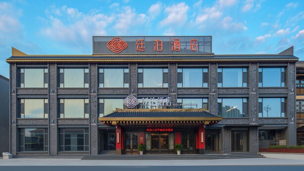 A modern hotel with a prominent sign and a traditional entrance.