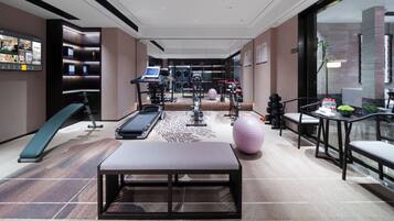 A fitness center with exercise equipment, a treadmill, and a seating area.