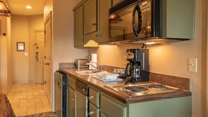 A compact kitchen with a built-in stove, a coffee maker, and a toaster. - Big Cedar | Rustic Retreat | Pools, Lake & Adventure (Ridgedale)