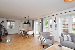 Amplia sala de estar con mesa de comedor, dos sofás y chimenea.