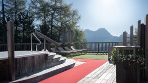 A wooden deck with a red carpet leading to a set of stairs, overlooking a body of water and mountains. - Room 8 with Mountain View (Badia)