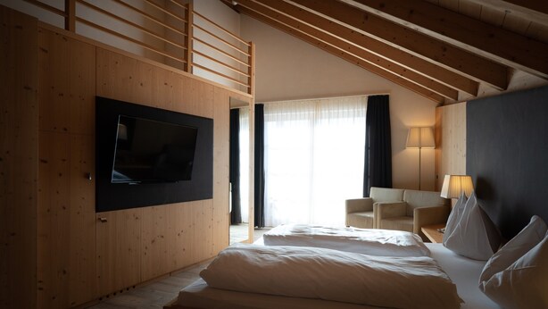 A hotel room with a bed, a TV mounted on the wall, a desk with a lamp, and a chair. - Room 11 with Mountain View (Badia)