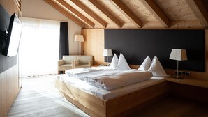 A bedroom with a wooden ceiling, a bed with white bedding, a chair, two bedside lamps, and a blackboard wall. - Room 11 with Mountain View (Badia)