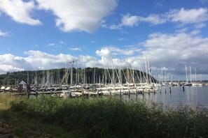 A marina with multiple boats docked, surrounded by greenery and a clear sky. - Marina-Fördeblick (Luck 2) (Glücksburg)