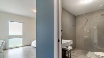 Une salle de bain moderne équipée d’une douche, de toilettes et d’un lavabo.