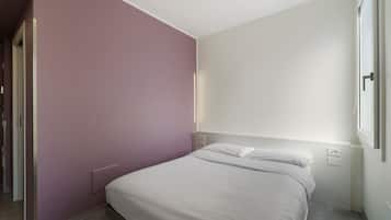Une chambre à coucher avec un lit, une porte et une fenêtre.