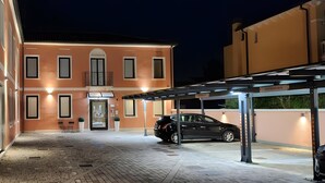 A building with a covered parking area and a car parked inside.