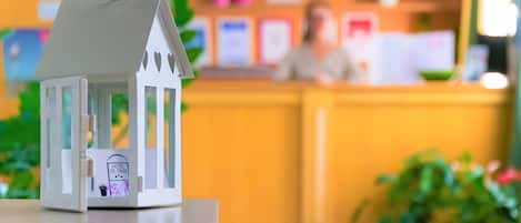 A model of a white building with a sign that reads 'HOTEL CA' TRON' and a bicycle illustration.
