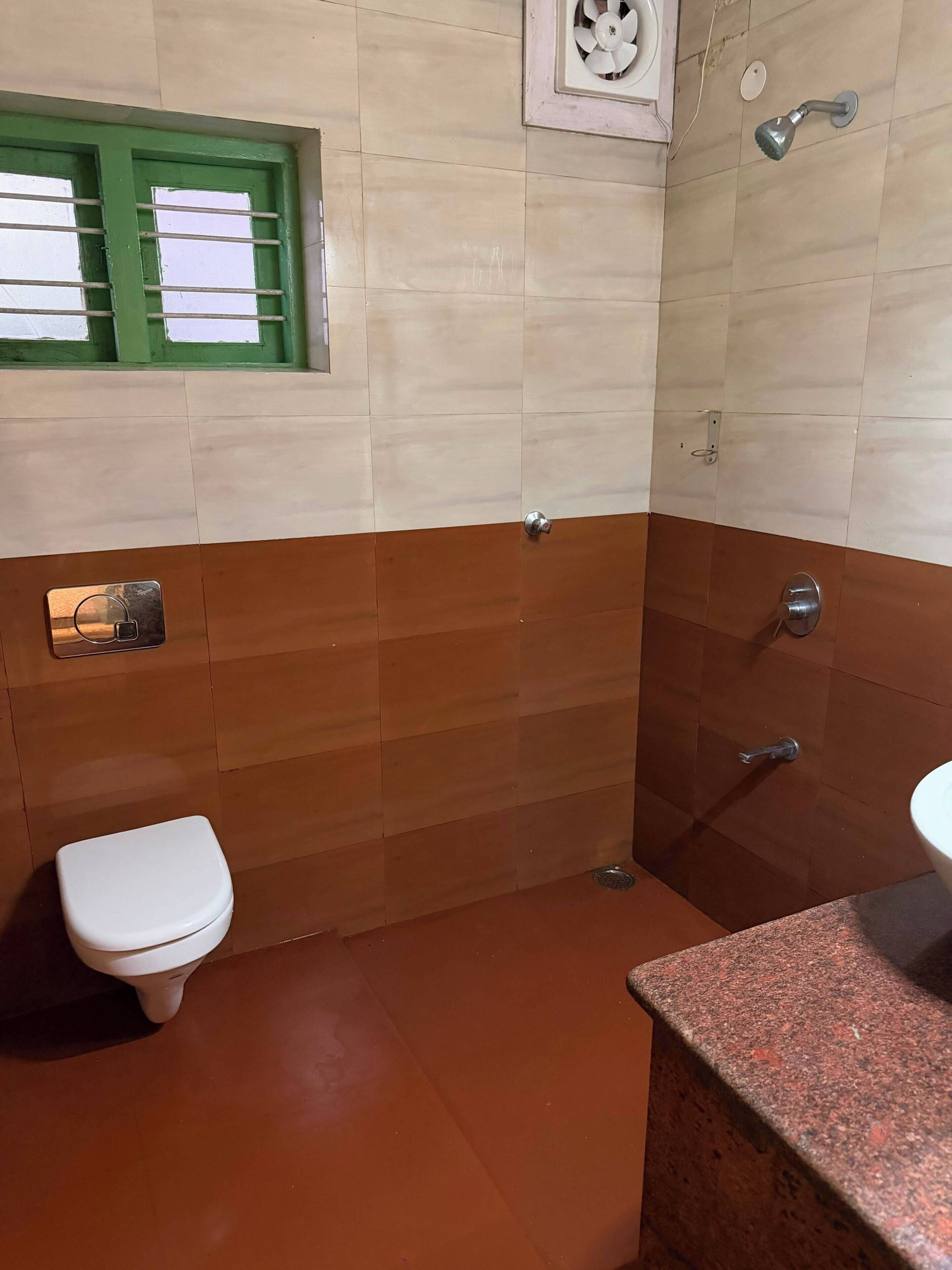 Un baño con inodoro, ducha y lavamanos.