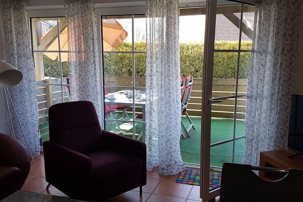 Ein Zimmer mit einer Schiebetür zum Außenbereich, inklusive Tisch und Stühlen.