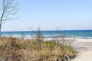 A beach path leading to the sea with sparse vegetation and a clear sky. - Holiday apartment with 1 bedroom (Scharbeutz)