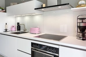 A modern kitchen with a built-in oven, a stovetop, and a coffee maker. - Holiday apartment with 1 bedroom (Scharbeutz)