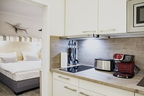Una kitchenette compacta con estufa, tostadora y cafetera.