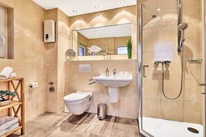 Un baño moderno con inodoro, lavabo y ducha.