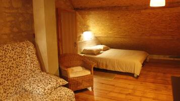 Een gezellige kamer met een bed, een stoel en een lamp.