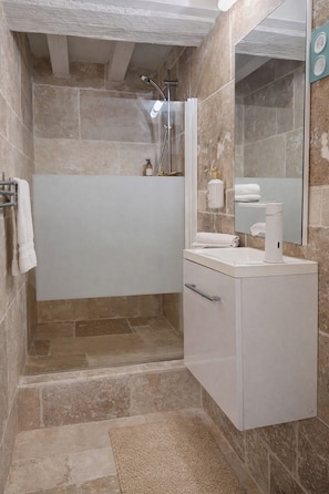 Un bagno con doccia, un water e un lavandino.